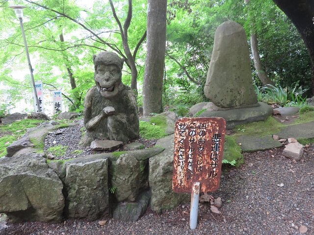 愛知県犬山市の桃太郎神社の凶のおみくじを食べるサル